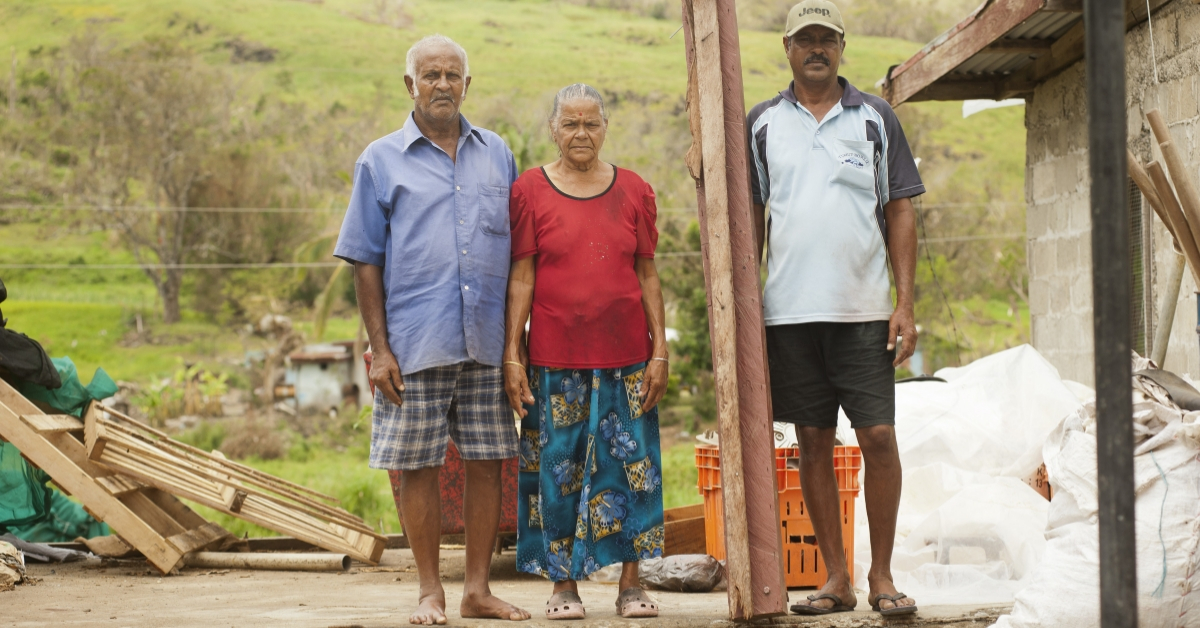 A family stands next to their destroyed home after a super-storm